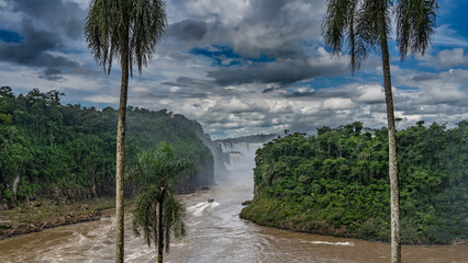 A stormy river skirts the island, covered with lush tropical vegetation. A tourist boat rushes in...