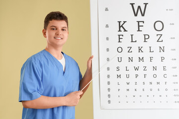 Teenage ophthalmologist with pointer and eye test chart on green background