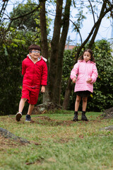 International Children Day. Very happy Latino children playing outdoors, running and smiling. Concept of family and fun. Nature.