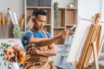 Middle-aged Asian man, skilled painting artist, donning an apron. Proficient in art, creativity, inspiration, and canvas work, utilizing various tools to express imagination.