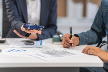 Asian businesswoman specializing in car loan services. Proficient in terms like extended warranty, lease, MSRP, and navigating financing options for customers' automotive needs.