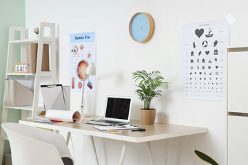Interior of ophthalmologist's office with workplace and eye test chart