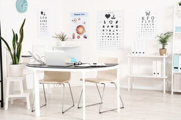 Interior of oculist's office with workplace and eye test charts