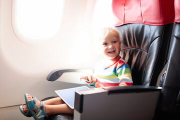 Child in airplane with tablet computer.