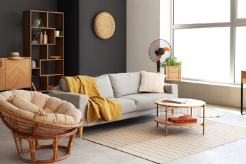 Interior of stylish living room with modern electric fan and grey sofa