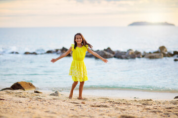 Little girl playing on tropical beach