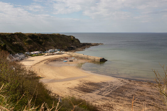 Porth Nefyn harbour and Nefyn beach viewed from on top of a cliff in evening sunlight. Nefyn is a village situated on the LLyn Peninsula in North Wales.