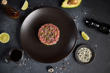 Tuna and avocado tartare on a dark ceramic plate
