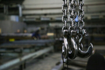 Lifting mechanism iron chain with a hook of an overhead crane on the background of industrial...