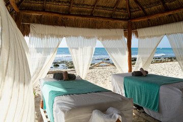 Fototapeta na wymiar Caribbean beachfront and ocean view hut spa with empty massage table, offering prospective clients panoramic views and relaxation in Mexico