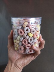 hand holding a jar of cereal
