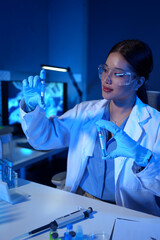 A research scientist or doctor is viewing and storing a sample of a substance for research with test tubes doing research in a clinical laboratory to test a solution or drug in a laboratory.