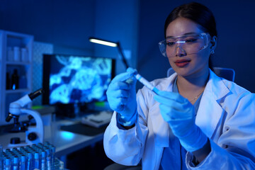 A research scientist or doctor is viewing and storing a sample of a substance for research with...