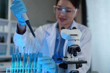 Fototapeta premium Scientist working in laboratory using micropipette Mixing liquid chemicals with genetically modified samples under a biotechnology microscope. Development of microbiology research experiment.