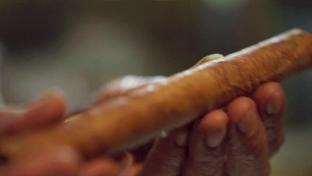 A man rolls tobacco by hand to make a cigar