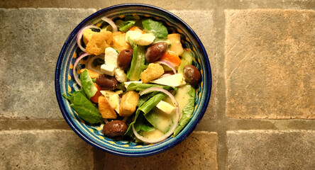 homemade Greek salad with Feta cheese, Kalamata olives, Romaine lettuce, red onion, celery, carrot, croutons and Italian vinaigrette dressing 