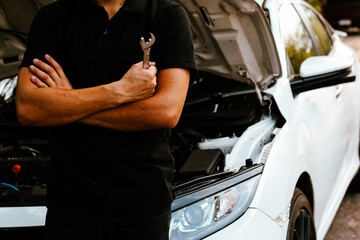 Auto mechanic working on car engine