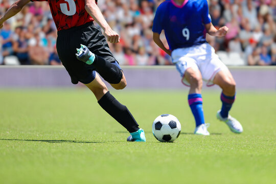 サッカーの試合でボールを蹴るる選手