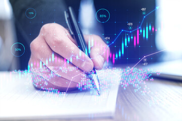 Close up of male hands doing paperwork with growing forex chart on blurry background. Toned image....