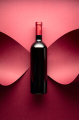 Bottle of red wine on a red background.