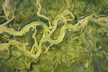 Fototapeta premium An aerial view of the terrain features created by river erosion, surrounded by lush green vegetation.