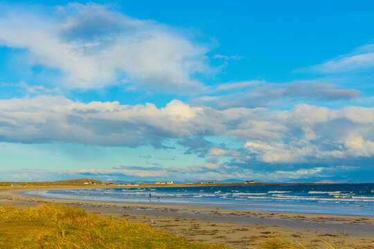 Gott Bay, Isle of Tiree, Inner Hebrides, Scotland in Springtime with whitewashed cottages, blue sky, machair, and a choppy sea. Hoirzontal.  Space for copy