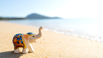 figurine of elephants on the sandy beach. exotic vacation or vacation concept