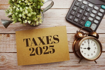 Taxes 2025 typography text with calculator on wooden background