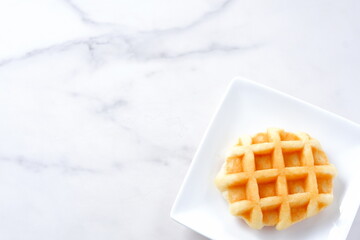 バターをたっぷり使って焼き上げた格子模様の洋菓子のワッフル
