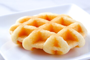 バターをたっぷり使って焼き上げた格子模様の洋菓子のワッフル
