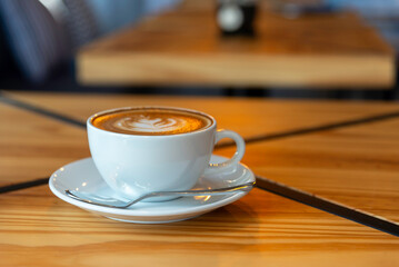 Hot latte art coffee cup on wooden table
