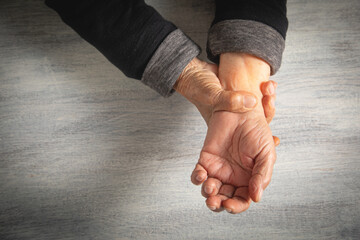 Caucasian elderly woman suffering from pain in hand.