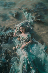 top view, aerial view of a mermaid or sea siren with blue hair laying on the azure water, wearing detailed dress from pearls, seashells and lace, dreamlike, fantasy, fairy tale fashion photography