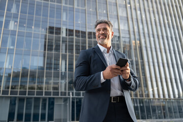 Portrait of European latin middle age male entrepreneur businessman working on mobile cell phone....