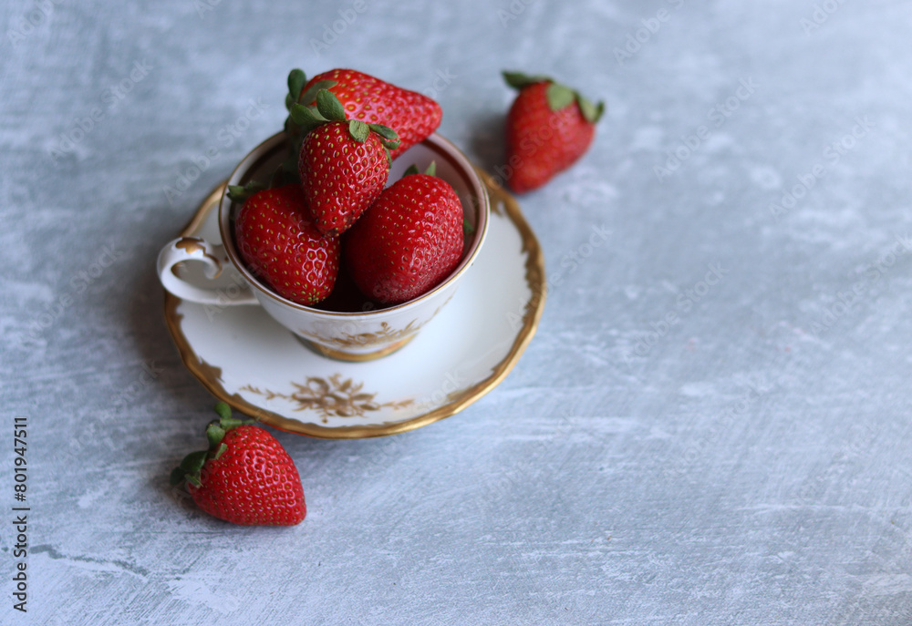 Sticker Strawberries in a porcelain cup on a light grey background with space for text. Still life photo with retro tableware and summer fruit. Eating fresh concept. 