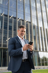Vertical portrait of European latin middle age male entrepreneur businessman working on mobile cell...
