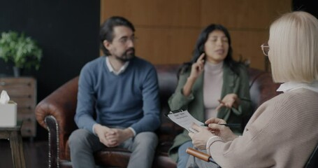 Troubled young people unhappy couple discussing family problems with professional therapist in modern office. People and relationship crisis concept.