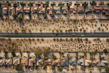 An aerial photograph illustrating the process of desertification, with urban residential areas surrounded by encroaching desert.

