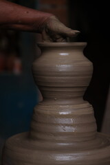 The potter works on a pottery wheel to made of soft colored clay, retro style toned Clay pots with hand and equipment