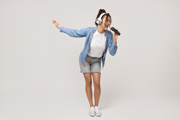 Attractive young girl in headphones with a microphone in her hands