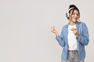 Attractive young girl listens to music in headphones