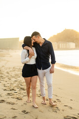 Tender couple embracing on the beach during sunset