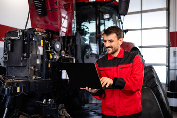 Professional serviceman checking diagnostic of the tractor agricultural machine.
