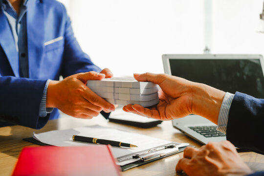 Legal expert navigating corruption cases, including bribery and graft. Businessman consults at desk. Discussions involve bribery, corruption, buying off, and corrupt practices.