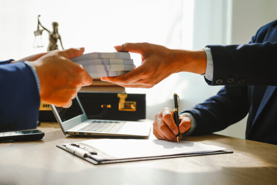 Legal expert navigating corruption cases, including bribery and graft. Businessman consults at desk. Discussions involve bribery, corruption, buying off, and corrupt practices.