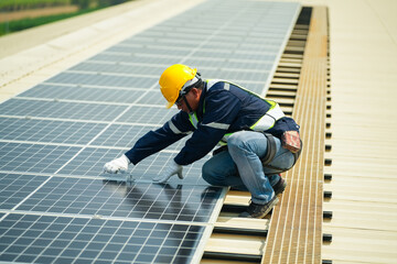Men technicians carrying photovoltaic solar moduls on roof of house. Builders in helmets installing...
