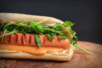 delicious hot dog with arugula and cheese sauce