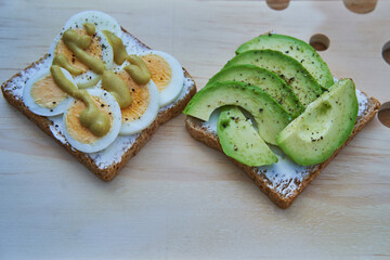 Two open face sandwiches on the cutting board. Healty and balanced snack consist form wholegrain...