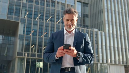 Successful mature hispanic senior business man using smartphone cellphone financial application. Indian or latin confident middle age male entrepreneur businessman holding mobile cell phone for invest - Powered by Adobe