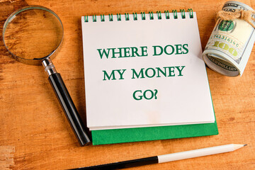 Question WHERE DOES MY MONEY GO on a notebook with a magnifying glass and a roll of money on a...